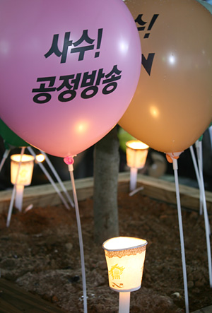 '사수 공정방송'이라고 쓰여진 풍선과 촛불