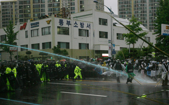 경찰들이 노동자들에게 색소를 탄 물대포를 쏘고 있다.